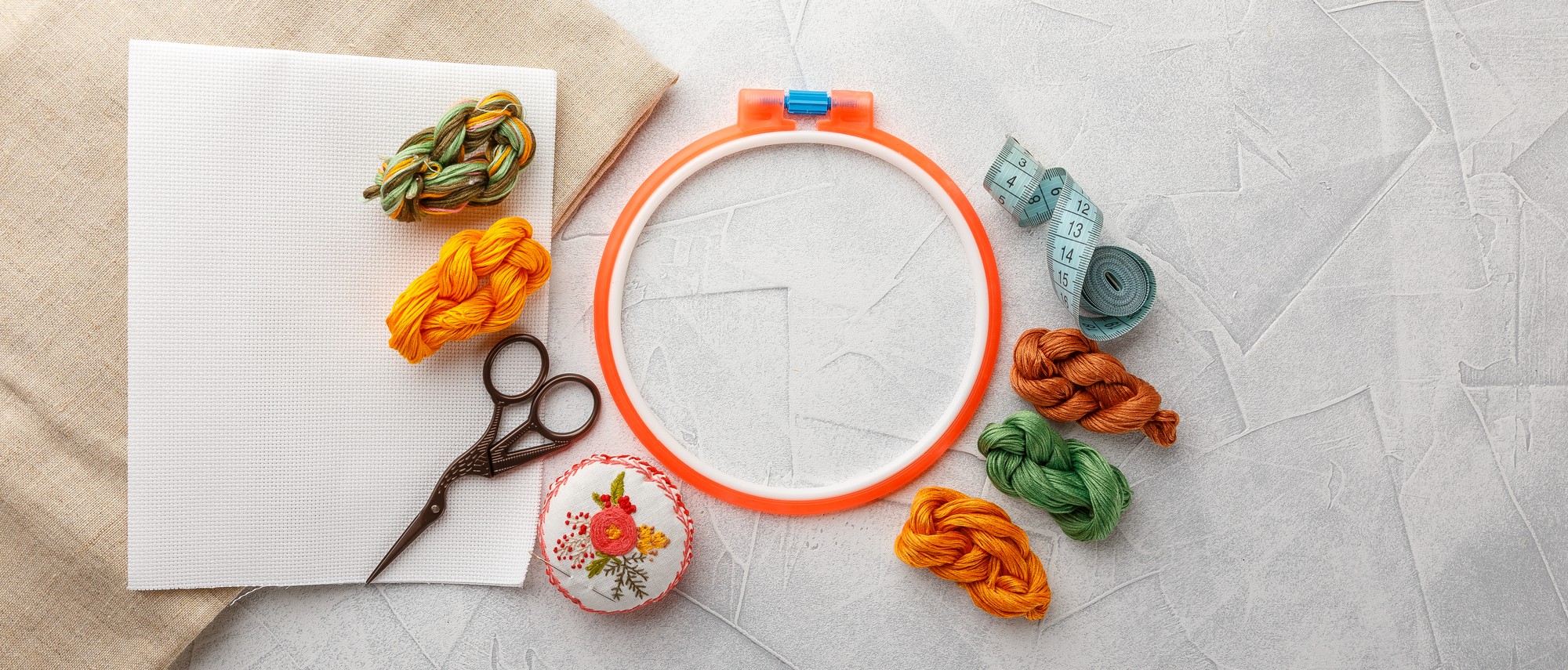 Workspace with hoop, threads and neat stitches on fabric